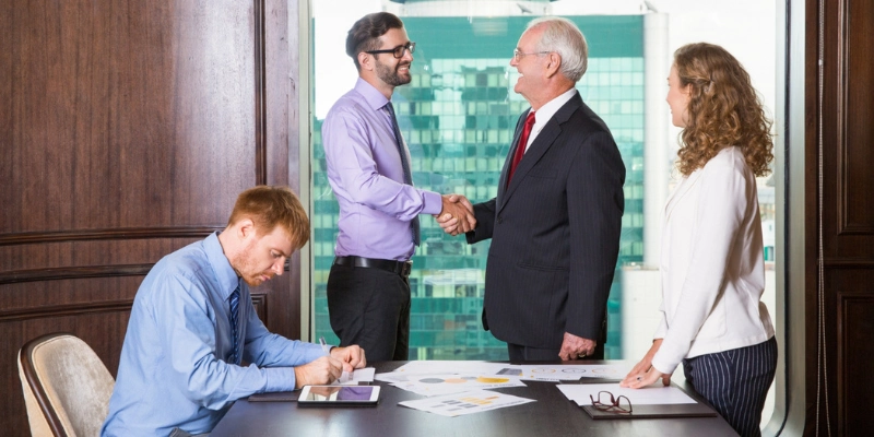 Real estate professionals meeting and shaking hands to build referral relationships