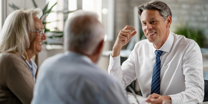 Older couple speaking with a real estate referral professional